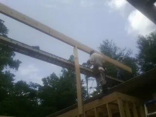 Carpenter setting a ridge beam over a new addition frame — Ice Dam Removal by Roofing Brothers in Gibbon Glade