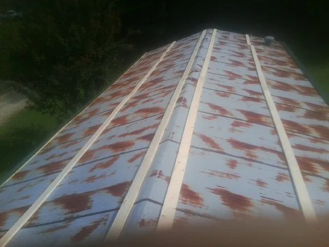 Rusted metal roof panels with new wood purlins before replacement — Storm Damage Roof Repair in Gibbon Glade by Roofing Brothers
