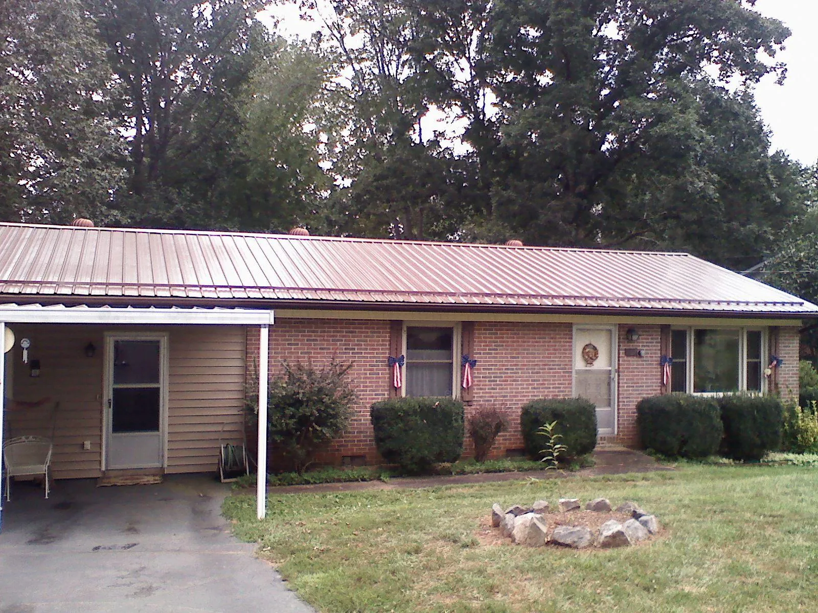 Bronze metal roof and carport on a brick ranch home — Roof Repair work by our crew in Gibbon Glade